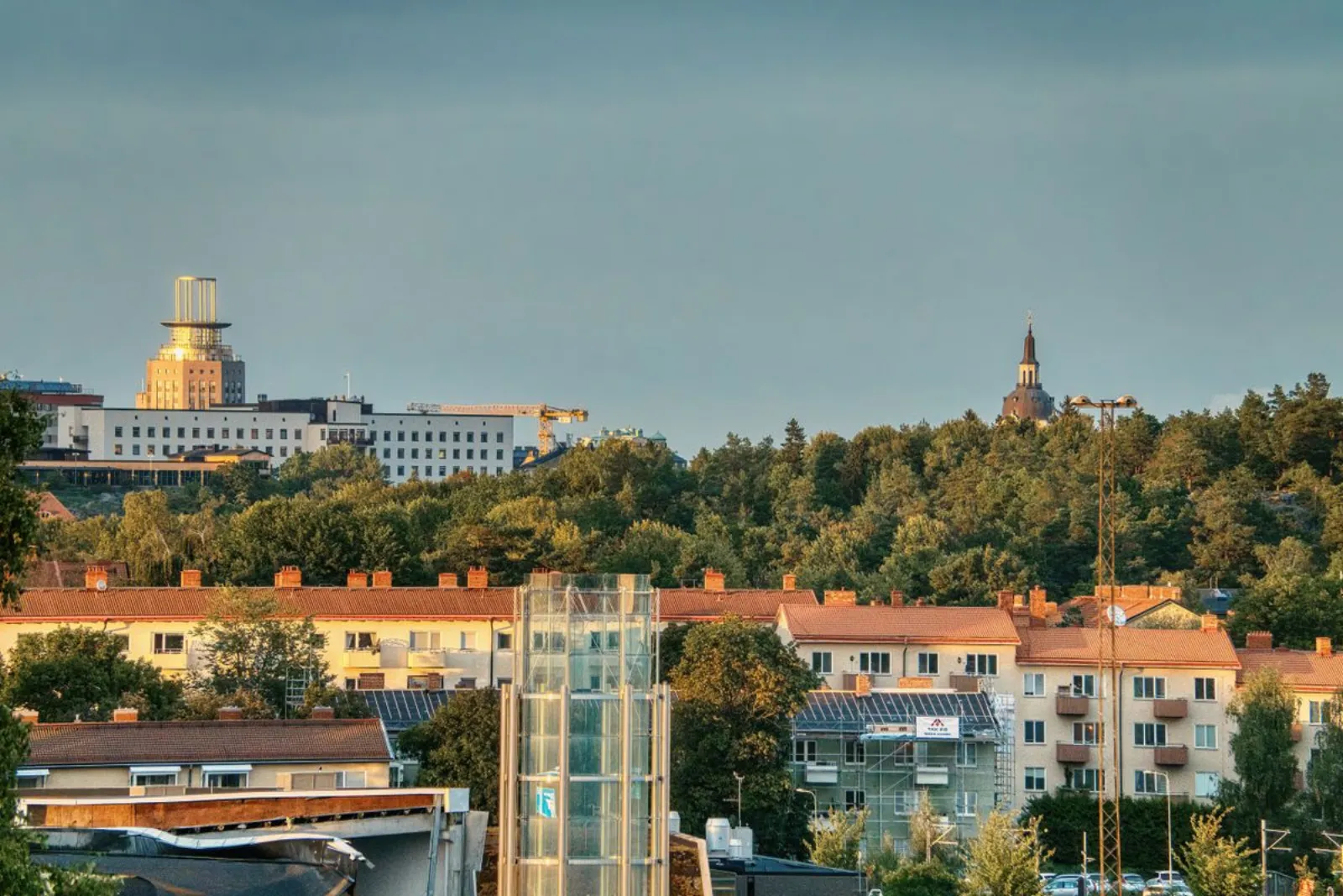 Utsikt över bostadsområde med flerfamiljshus och skog i Stockholmsförort