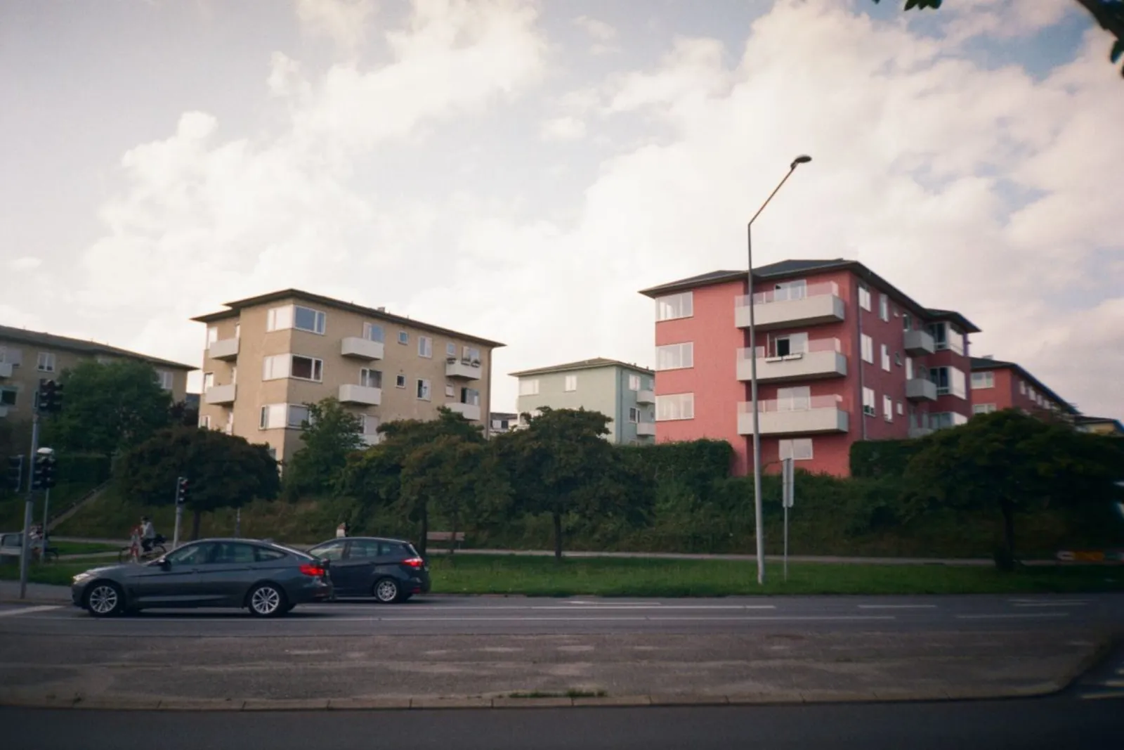 Flerfilig genomfartsgata med bilar framför bostadshus
